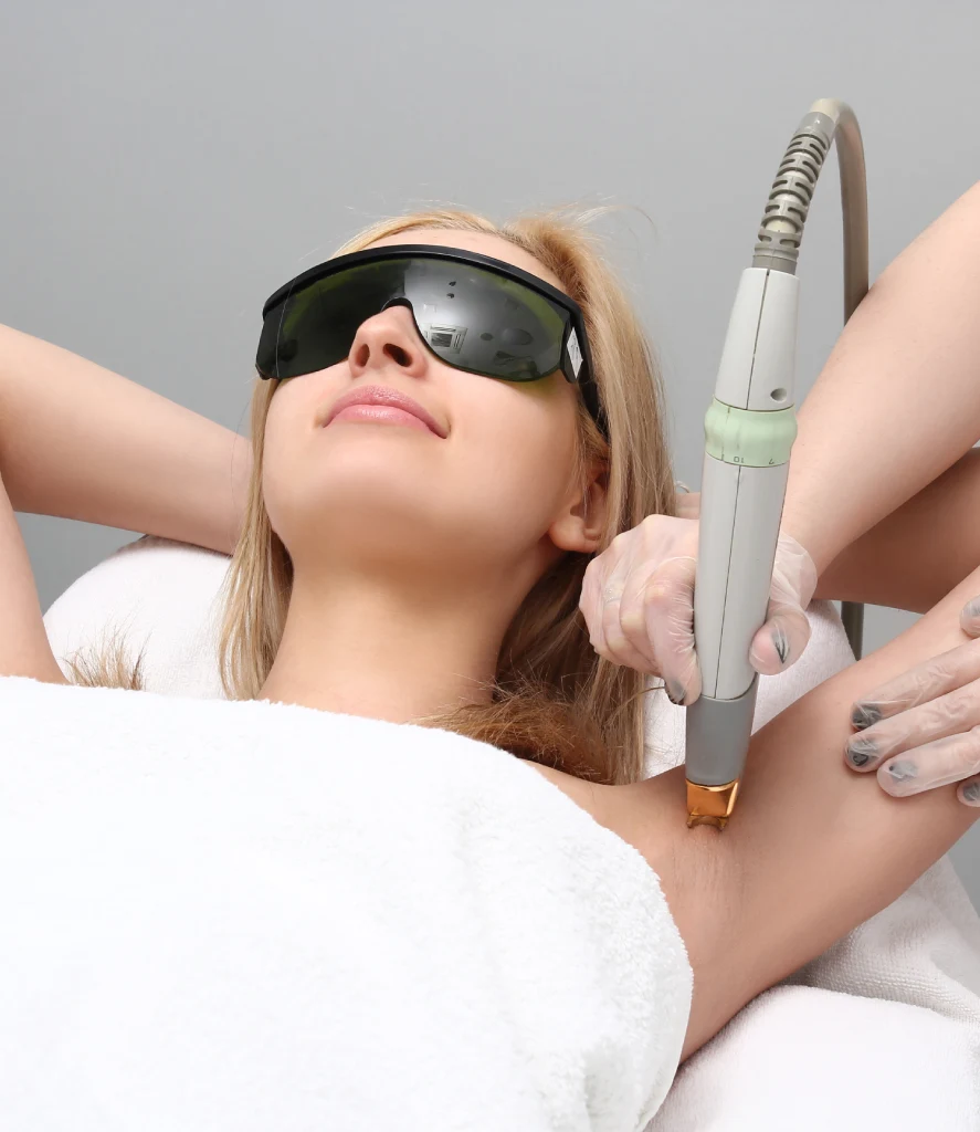 Close-up of a technician performing laser hair removal treatment on a woman’s underarm using a handheld laser device. The procedure takes place at Refine Med Spa in Centennial CO and targets unwanted hair with precision and care.