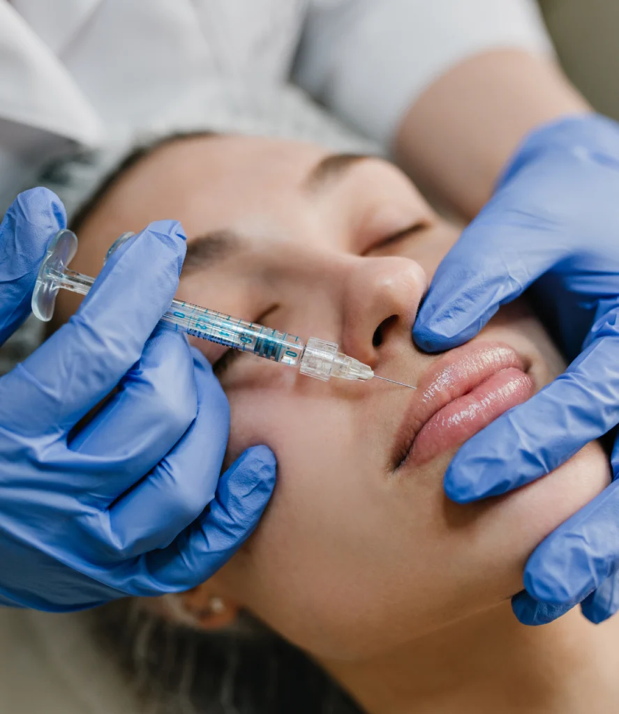 A middle-aged woman receives venous lake removal treatment on his lower lip at Refine Med Spa in Centennial, Colorado. A specialist uses a precise laser device to target the dark purple vascular lesion during the procedure.