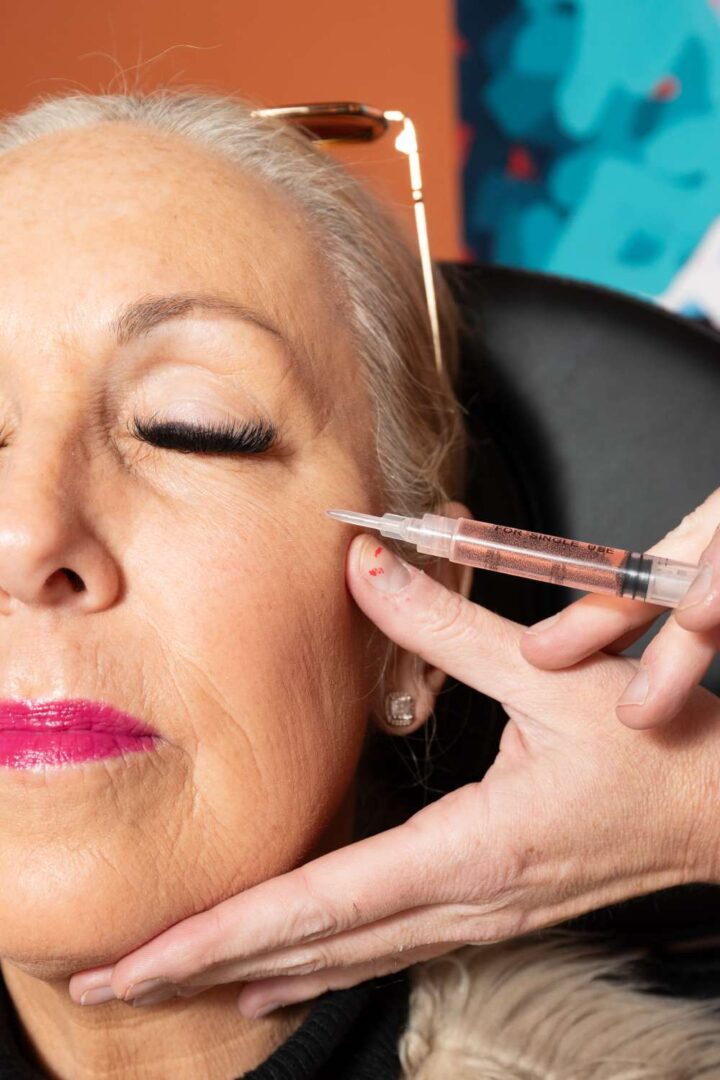 Older woman receiving cosmetic cheek injection
