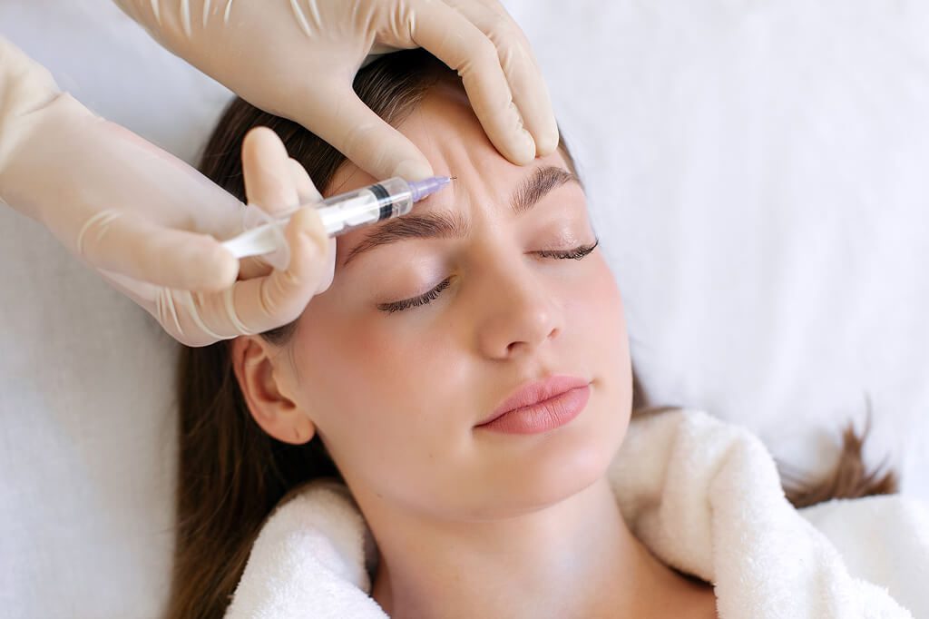 Woman receiving cosmetic forehead injection