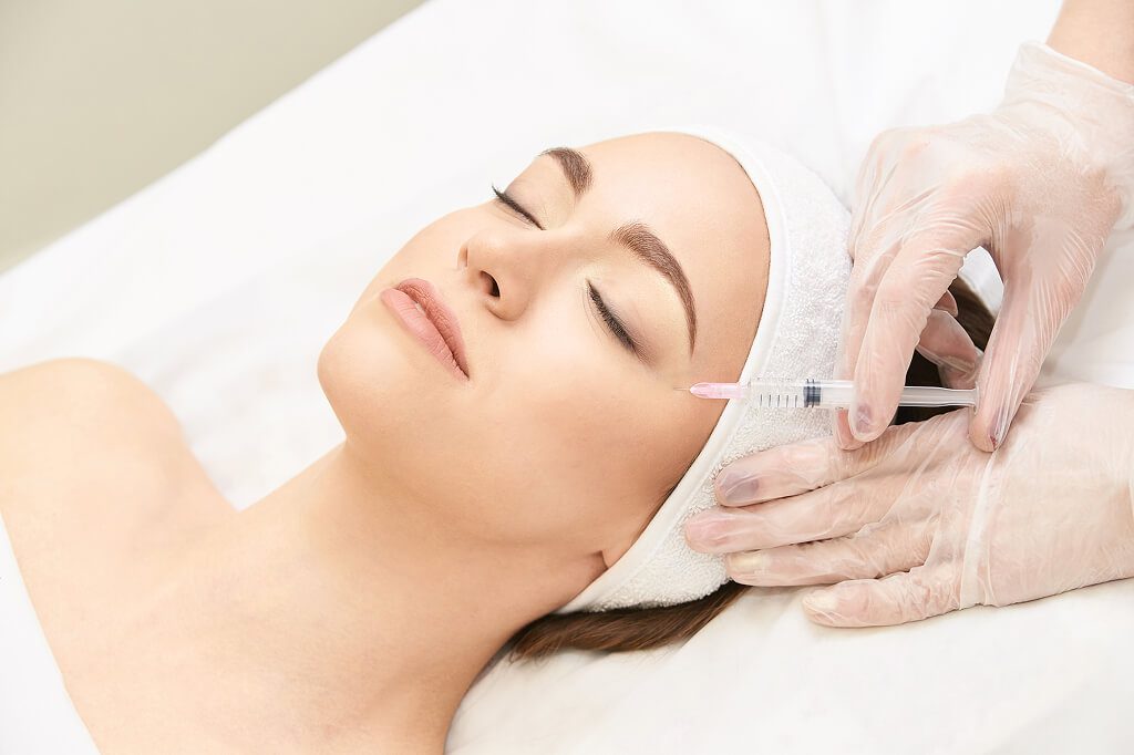 Woman receiving facial dermal filler injection