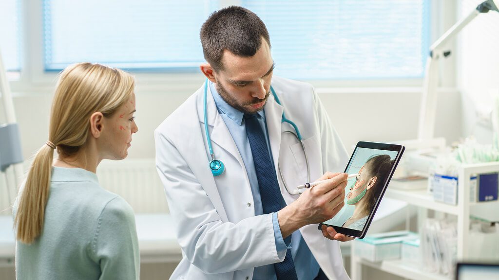 Doctor showing patient facial scan on tablet