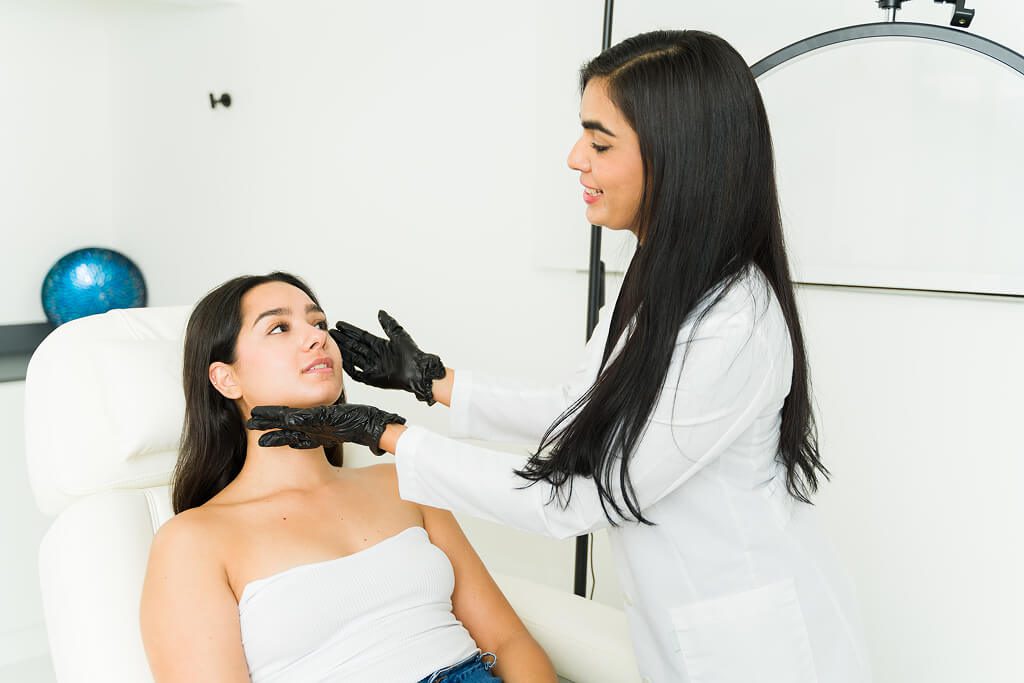 Dermatologist examining woman's neck and jawline
