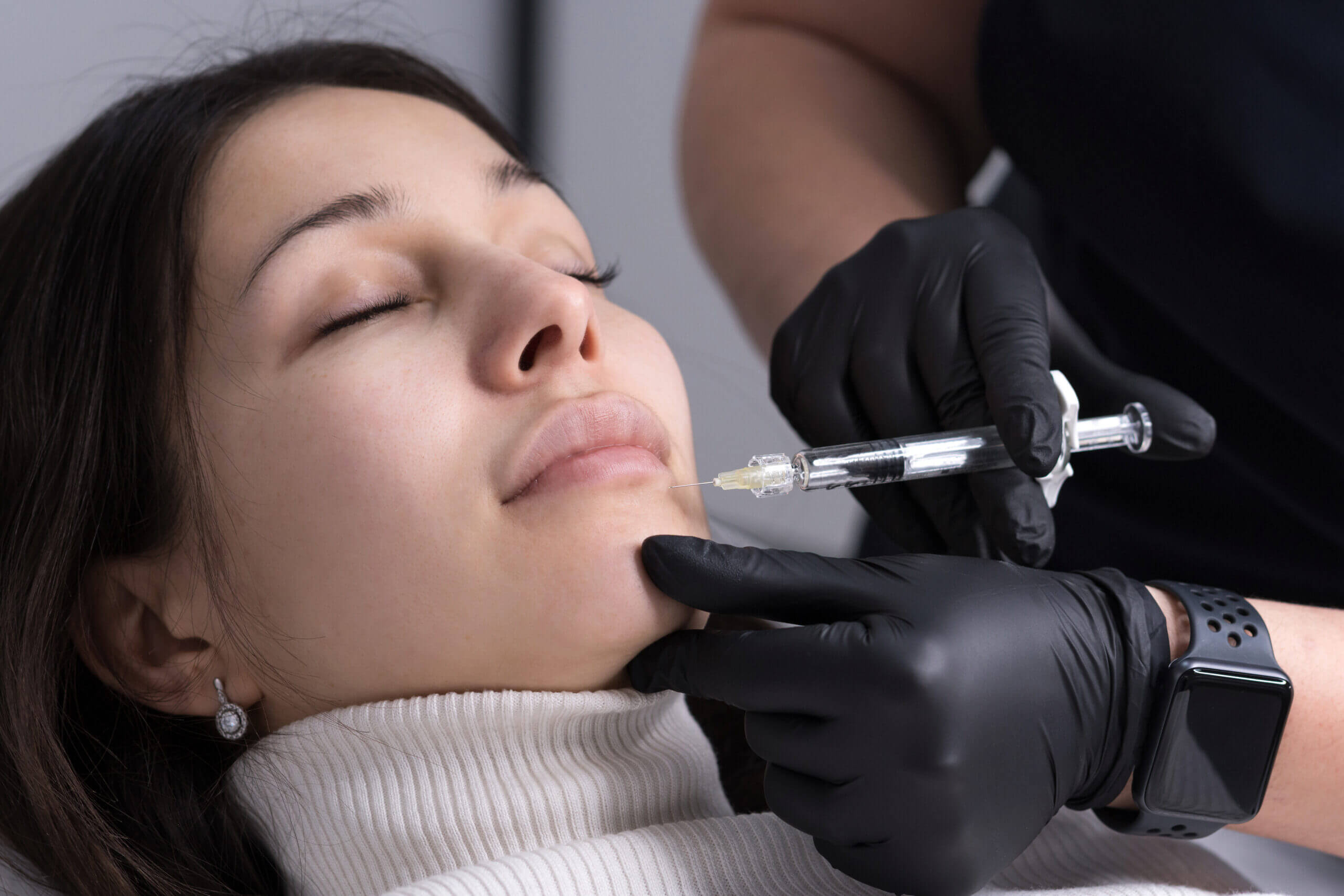 Woman receiving cosmetic chin injection