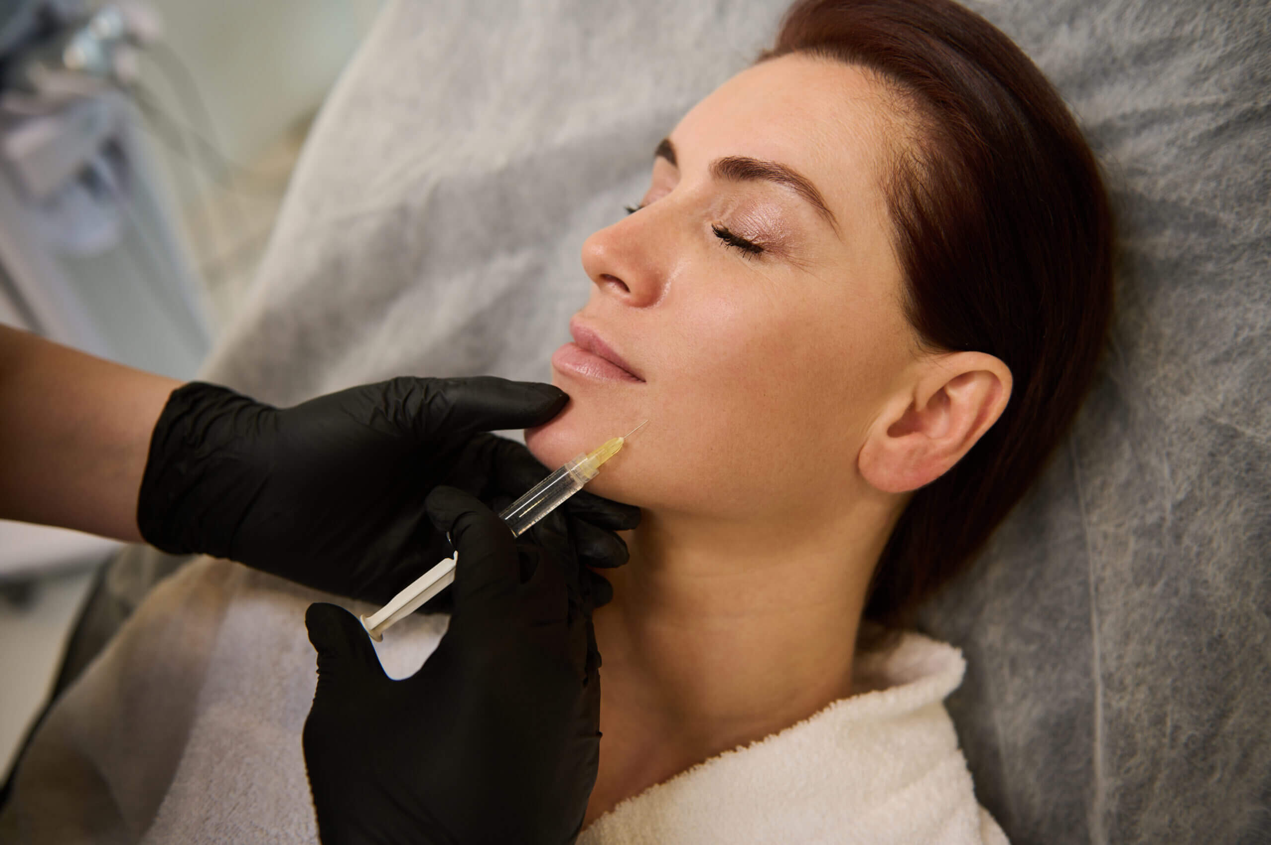 Dermal filler injection into woman's chin