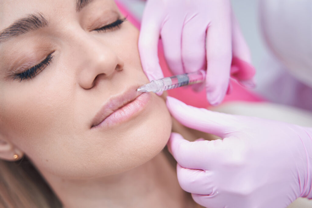 Close-up of woman receiving lip filler injection