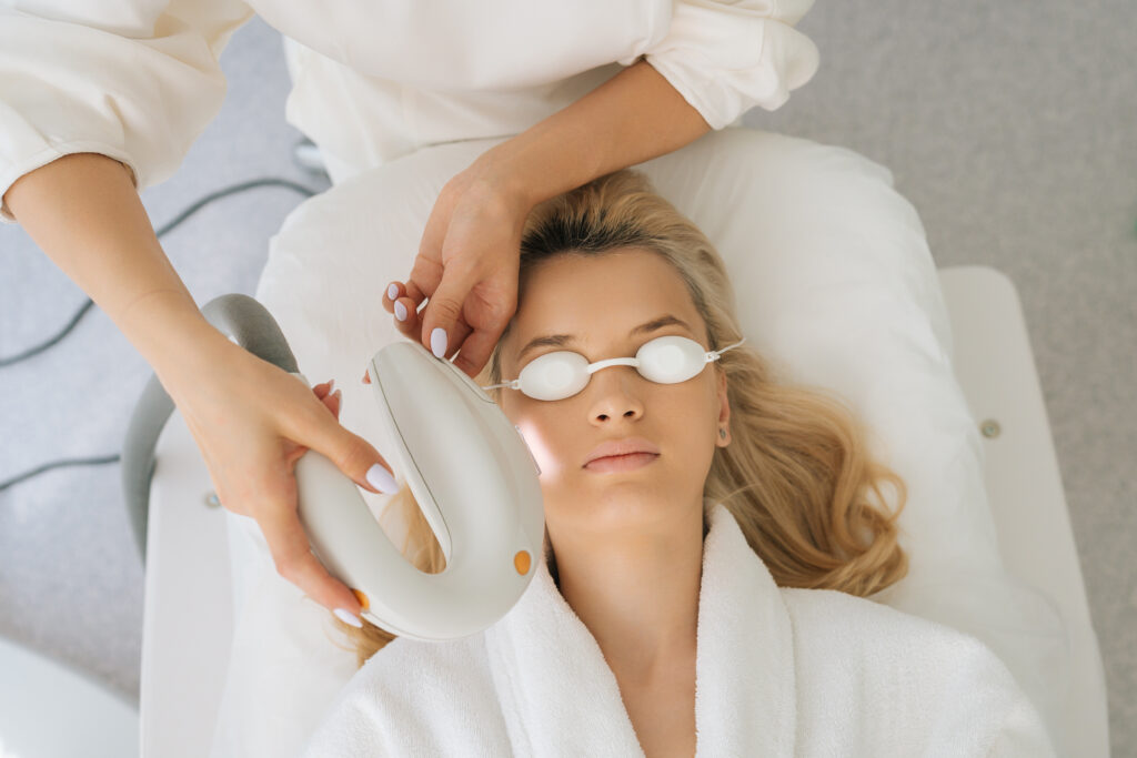 Woman receiving facial light therapy wearing eye shields