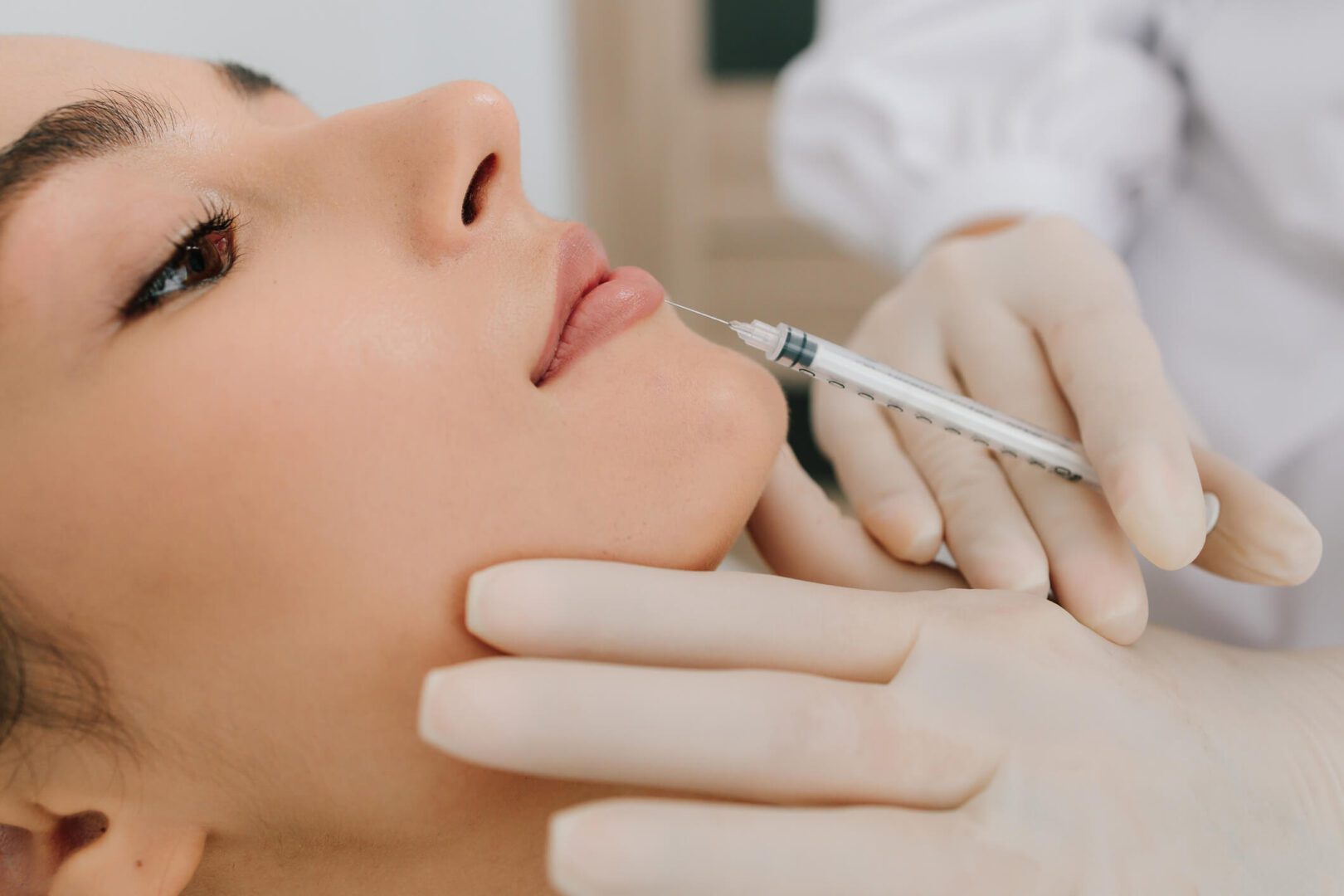 Close-up lip filler injection with gloved hands